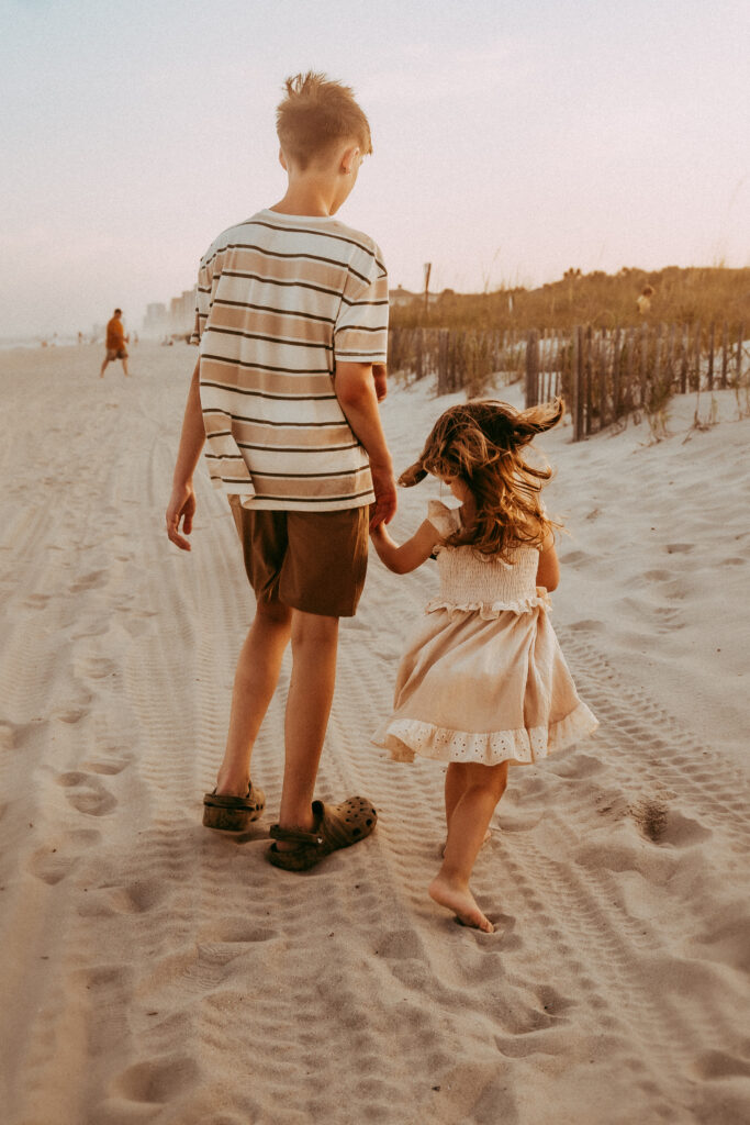 wo young kids playing in sand at Myrtle Beach SC during family photography session by Moody Momma