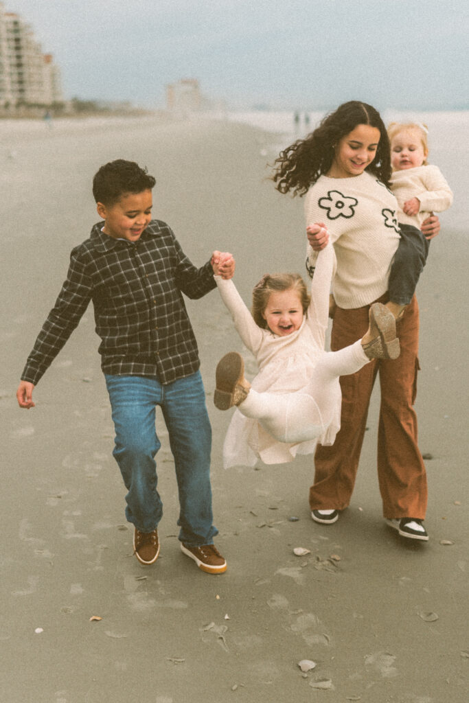 Family walking along Myrtle Beach  wearing neutral outfits
