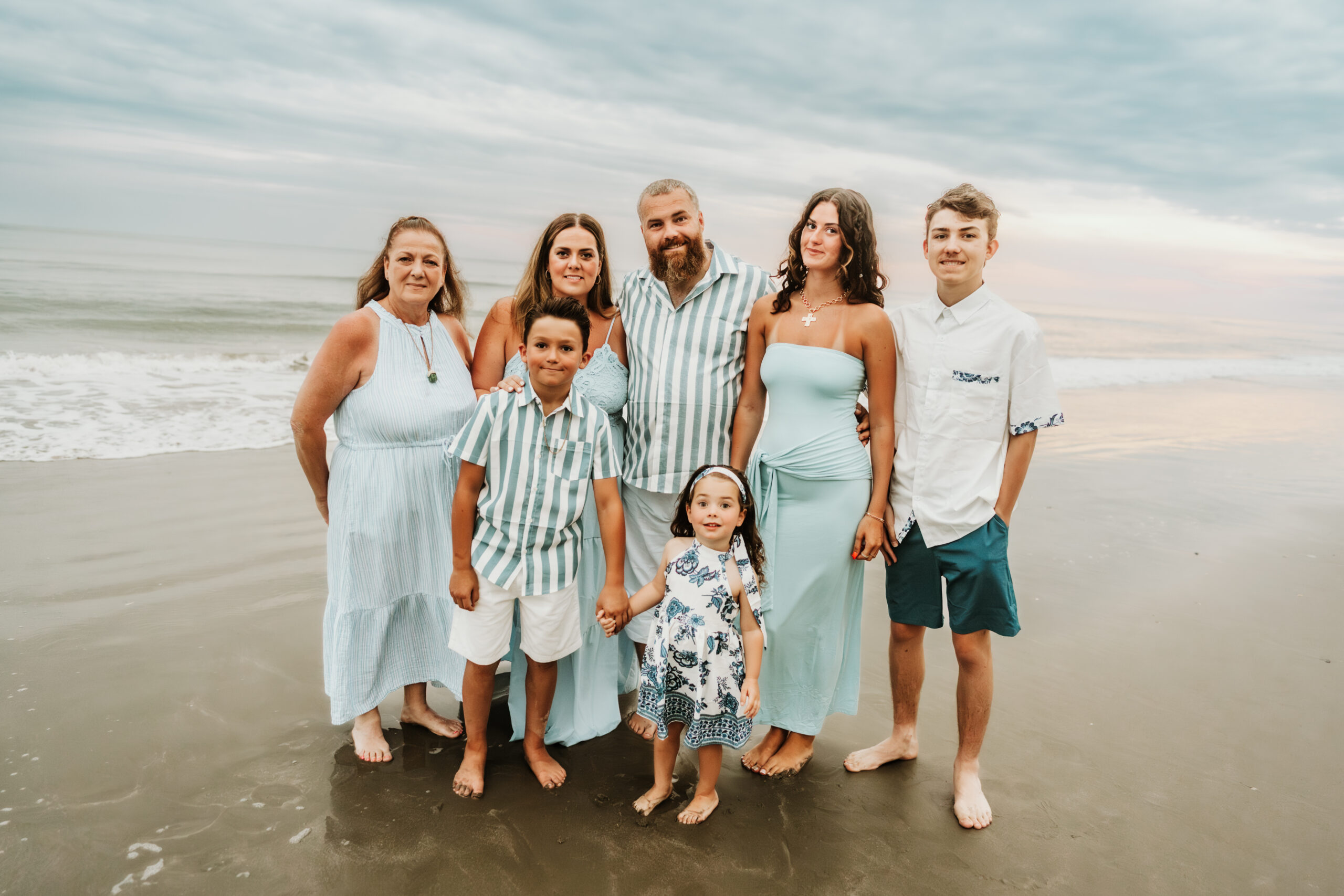 family walking along the shoreline during a sunset session in Myrtle Beach South Carolina